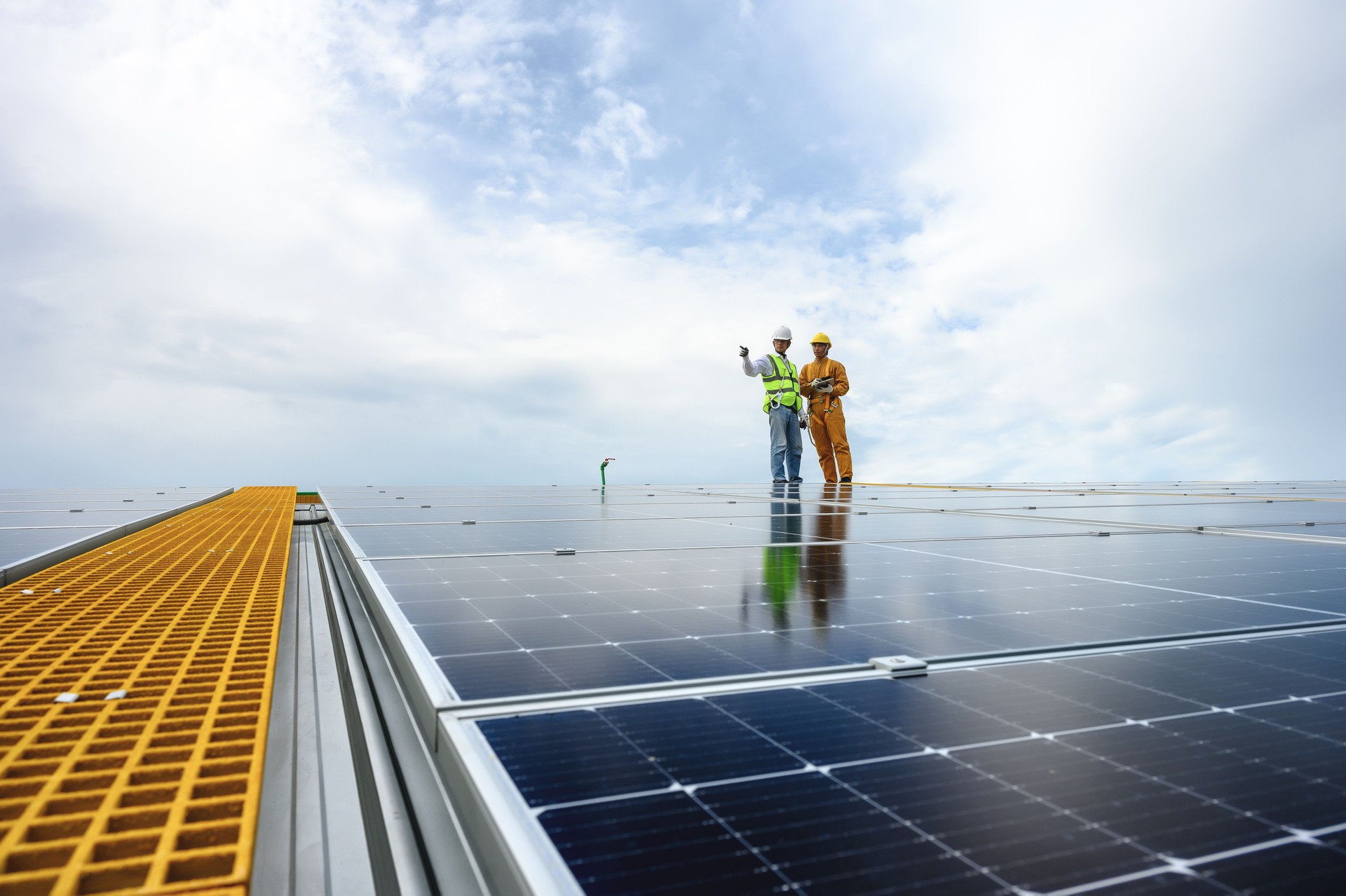 Engineer Inspector Quality in Solar Roof Panel Installation with Technician, Quality Control in Work of Sustainable Photovoltaic Installation on Factory Roof Buildings.